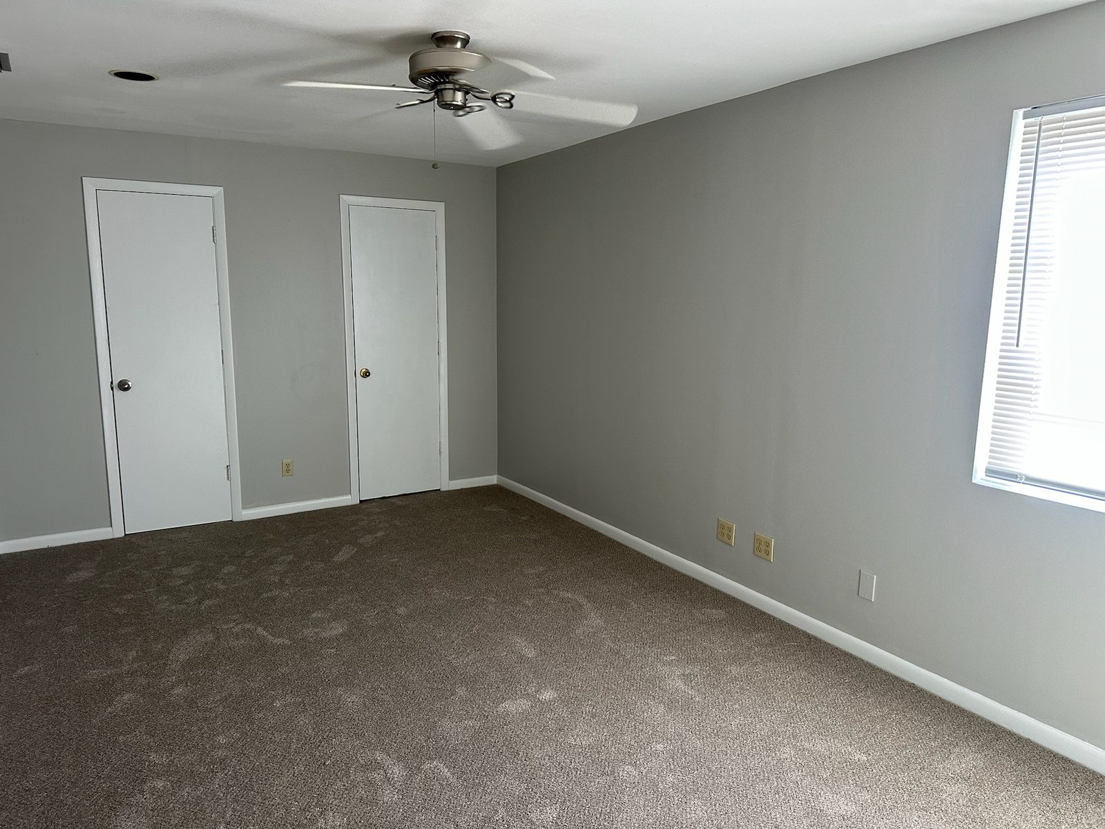 Bedroom corner after interior paint with crisp white baseboards