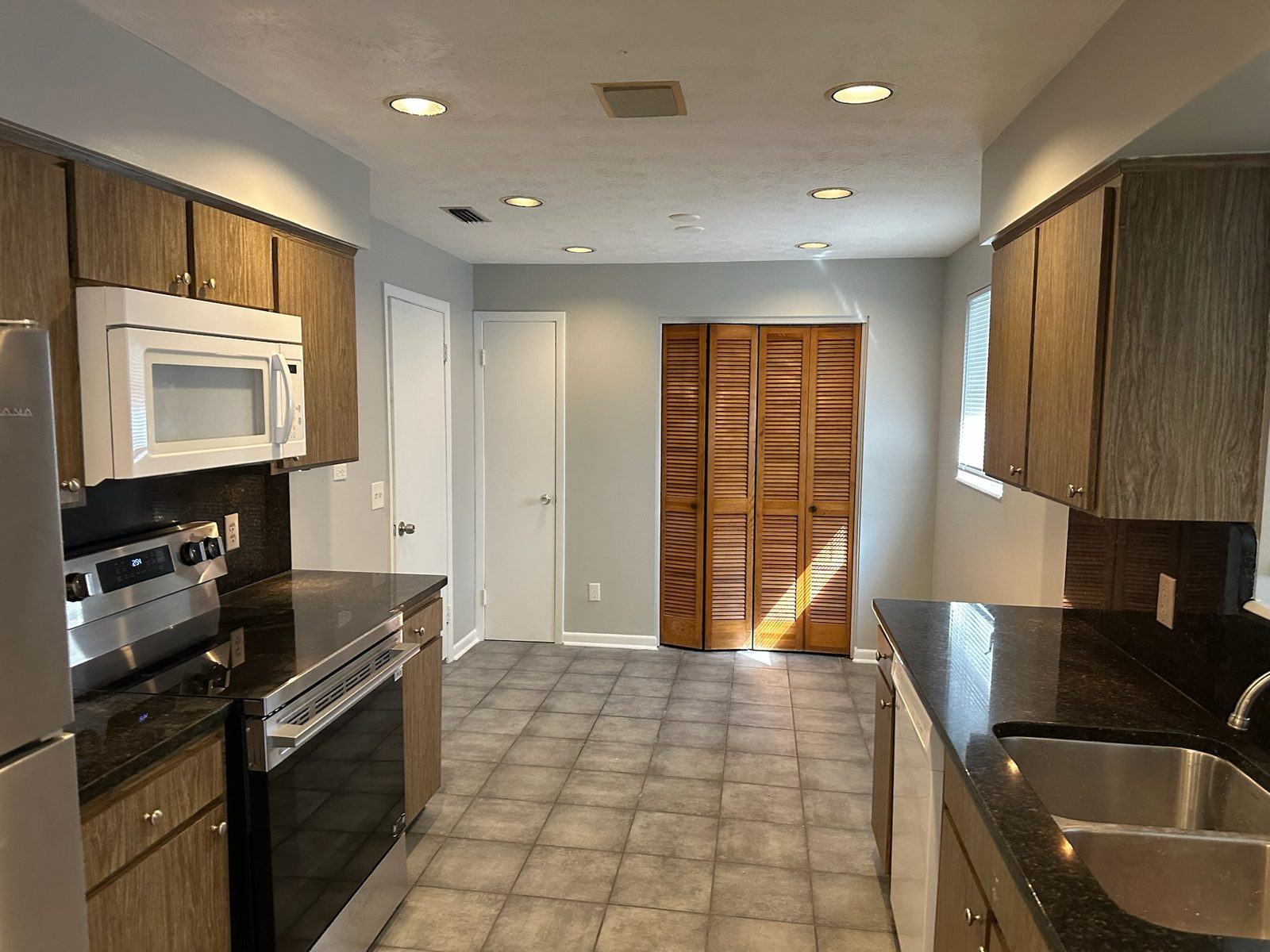 Kitchen after interior painting — gray walls, white trim, clean cut-in